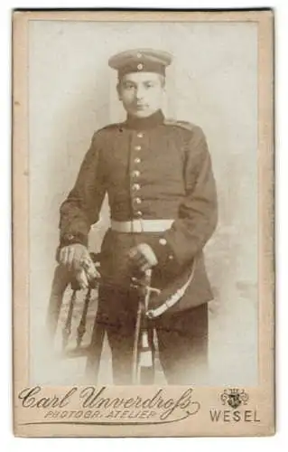 Fotografie Carl Unverdruss, Wesel / Rhein, Soldat in Uniform mit Säbel, Portepee und Krätzchen