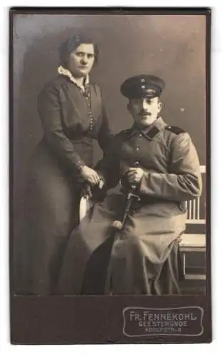 Fotografie Fr. Fennekohl, Geestemünde, Adolfstr. 8, Dame und Soldat in Mantel mit Säbel, Portepee und Schirmmütze