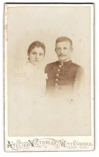 Fotografie Atelier Victoria, Wittenberg, Jüdenstrasse 1, Paarportrait, Dame und Uffz. in Uniform