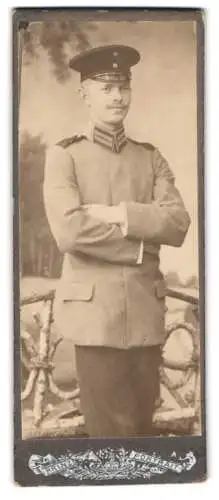 Fotografie unbekannter Fotograf und Ort, Soldat in feldgrauer Uniform mit Schirmmütze