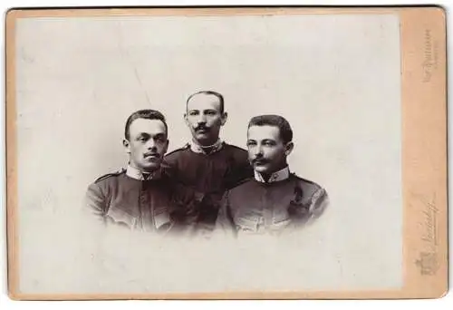 Fotografie Niederhoff, Komotau, Bahnhofstrasse 39, Drei k.u.k. Korporale in Uniform mit Schützenschnur, 1900