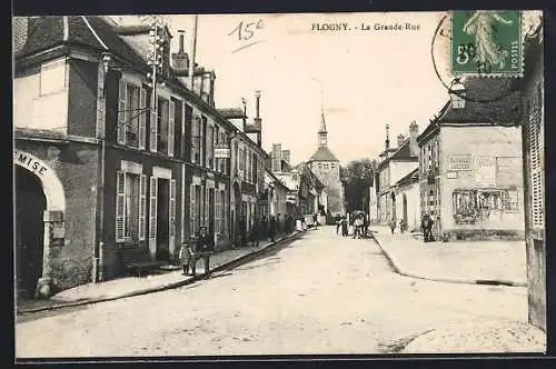 AK Flogny, La Grande Rue animée avec des passants et vue sur le clocher au fond