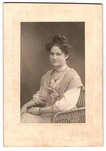Fotografie E. Stille, Lüdenscheid, Frau auf Korbstuhl mit elegantem Kleid