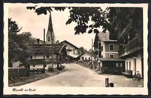 AK Kundl in Tirol, Strassenpartie mit Kirche