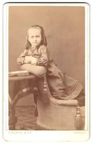 Fotografie A. Regis & Co., Berlin, Prinzen Strasse 38, Portrait eines jungen Mädchens im Kleid mit Haarband und Kruzifix