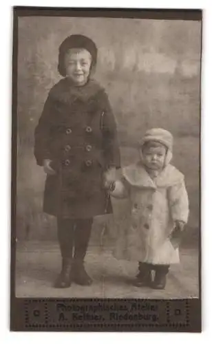 Fotografie A. Kettner, Riedenburg, zwei Kinder in Wintermänteln halten Händchen