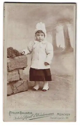 Fotografie Atelier Bavaria, München, Sendlingerstr. 59, Portrait eines kleinen Mädchens im Winterkleid mit Gamaschen