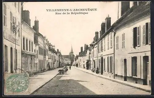 AK Villeneuve-l`Archevêque, Rue de la République avec perspective sur l`église au fond