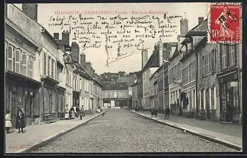 AK Villeneuve-l`Archevêque /Yonne, Rue de la République avec passants et bâtiments historiques