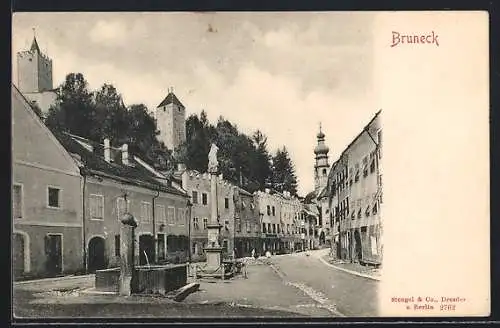 AK Bruneck, Strassenpartie mit Brunnen und Denkmal