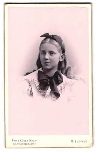 Fotografie Fritz Küken Nachf., Bielefeld, Porträt eines Mädchens mit langen blonden Haaren und Haarschleife