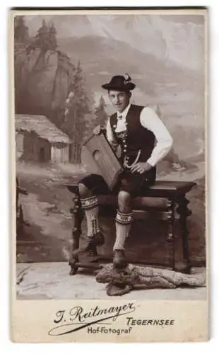 Fotografie J. Reitmayer, Tegernsee, CDV eines Mannes in Tracht mit Zither vor Studiokulisse