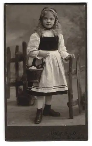 Fotografie Atelier Düll, München, Thalkirchnerstr. 36, Mädchen als Rotkäppchen mit Korb am Zaun, Fasching