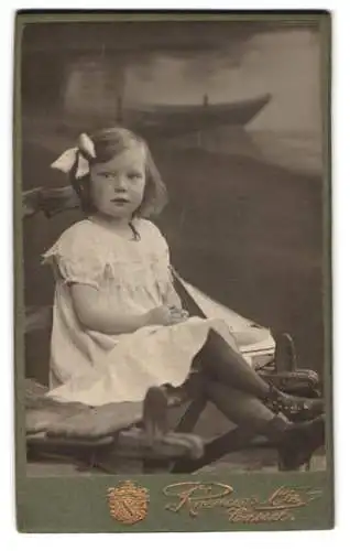 Fotografie Roemer & Cie, Cassel, Hohenzollernstrasse 96, Mädchen mit Schleife und Modell Segelboot