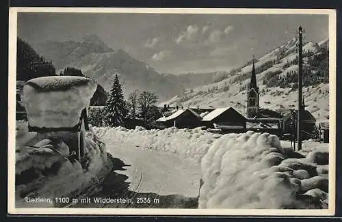 AK Riezlern, Strassenpartie mit Kirche und Widderstein im Schnee