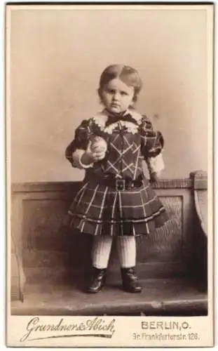 Fotografie Grundner & Abich, Berlin, Frankfurterstr. 126, Kind in kariertem Kleid