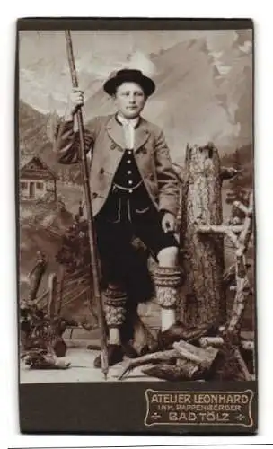 Fotografie Atelier Leonhard, Bad Tölz, Junge in Tracht mit Bergstock vor einer Studiokulisse