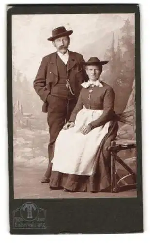 Fotografie Hermann Tietz, München, Bahnhofsplatz, Paar in traditioneller Kleidung