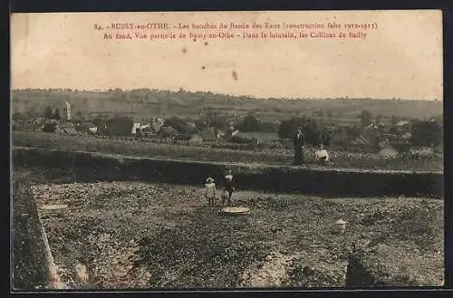 AK Bussy-en-Othe, Les bouches du Bassin des Eaux et vue partielle du village avec les Collines de Bailly