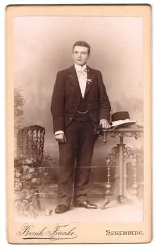 Fotografie Bernh. Franke, Spremberg, Eleganter Herr in Anzug mit Tisch und Stuhl