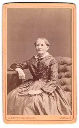 Fotografie A. Schnackenburg, Görlitz, Sitzende Dame in elegantem Kleid