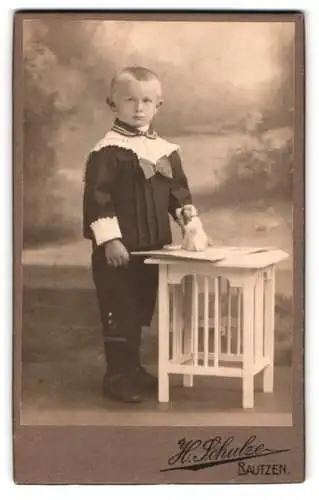 Fotografie H. Schulze, Bautzen, Kind mit Spielzeug auf Tisch