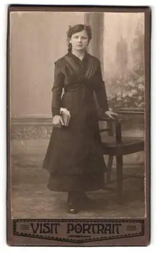 Fotografie Visit Portrait, Ort unbekannt, Junge Frau mit Buch und Stuhl
