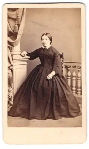 Fotografie F.A. Wilde, Weissenfels, Frau in elegantem Kleid vor Säulenbalustrade