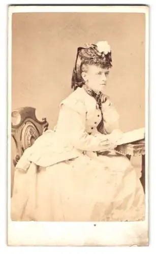 Fotografie R. Hatt, London, New Cross, Frau im eleganten Kleid an einem Tisch