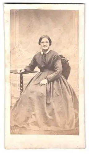 Fotografie unbekannter Fotograf und Ort, Sitzende Frau in elegantem Kleid