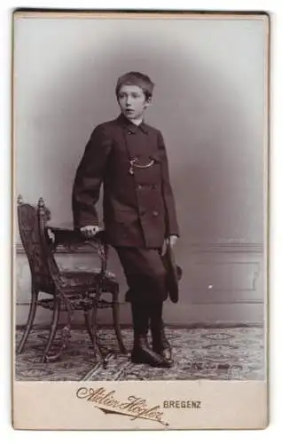 Fotografie Atelier Högler, Bregenz, Knabe im Anzug neben Stuhl