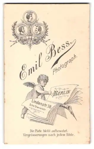 Fotografie Emil Bess, Berlin, Lindenstr. 38, kleiner Engel blättert in einer Zeitung mit Anschrift des Fotografen