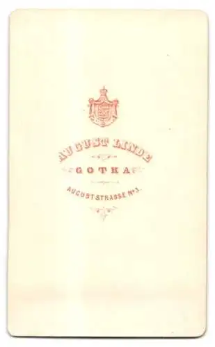 Fotografie August Linde, Gotha, Auguststrasse 3, Dame in elegantem Kleid an reich verziertem Möbelstück