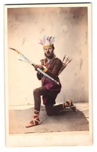 Fotografie R. Beyer, St. Petersburg, Schauspieler in fantasievoller Kostümierung mit Pfeil und Bogen, Handkoloriert