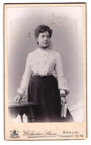 Fotografie Wilhelm Stein, Berlin, Chausseestr. 65/66, Frau mit Buch und Tisch