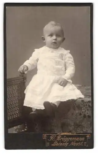 Fotografie Friedr. Brüggemann, Leipzig-Neustadt, Kleinkind auf einem Tisch