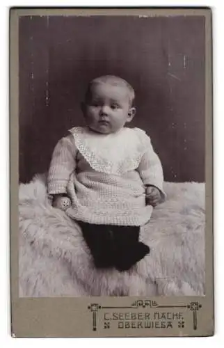 Fotografie C. Seeber Nachf., Oberwiesa, Kleinkind in gestricktem Kleid