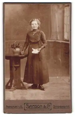 Fotografie Samson & Co, Frankfurt a. M., Frau im eleganten Kleid mit Blumenarrangement