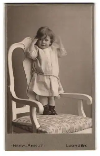 Fotografie Herm. Arndt, Ljungby, Kind auf Stuhl stehend
