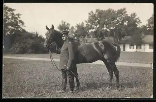 Foto-AK Soldat mit Reitpferd vor einem Gebäude