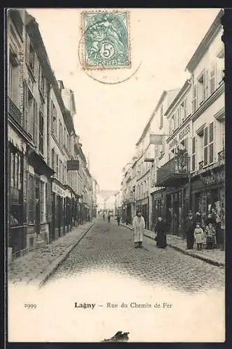 AK Lagny, Rue du Chemin de Fer animée avec passants et boutiques