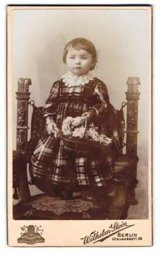 Fotografie Wilhelm Stein, Berlin, Chausseestr. 66, Kind mit Blumenkorb auf kunstvollem Stuhl