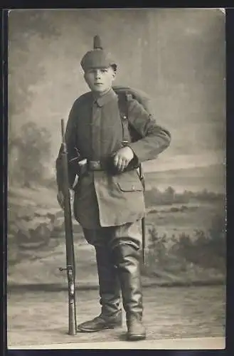 Foto-AK Soldat in Feldgrau Uniform mit Pickelhaube und Gewehr