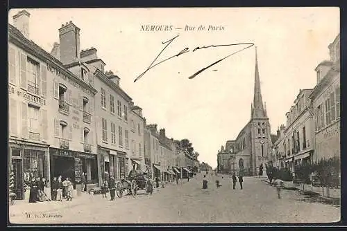 AK Nemours, Rue de Paris avec vue sur l`église et les commerces animés