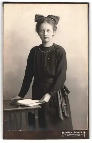 Fotografie Wilh. Boos, Pfarrkirchen, Mädchen mit Schleife und Buch