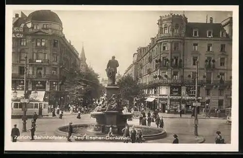 AK Zürich, Bahnhofplatz mit Alfred-Escher-Denkmal, Strassenbahn der Linie 6, Leute, Geschäfte, Hotel National