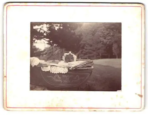 Fotografie unbekannter Fotograf und Ort, Baby im Kinderwagen im Freien