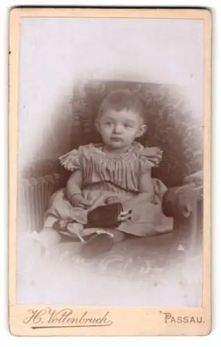 Fotografie H. Vollenbruck, Passau, Rindermarkt, Kind auf einem Sessel sitzend mit Puppe im Schoss