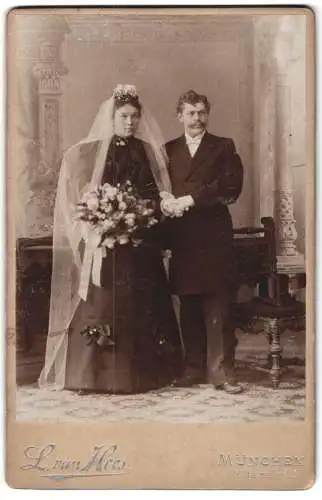 Fotografie L. van Hees, München, Müllerstr. 40, Hochzeitspaar mit Blumenstrauss im schwarzen Hochzeitskleid