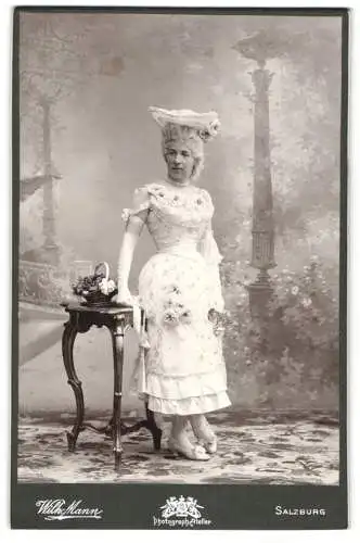 Fotografie Wilhelm Mann, Salzburg, elegante Dame in aufwendiger Garderobe, mit Blumen verziertes Kleid